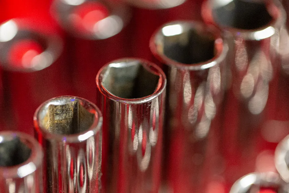 Soquetes de catraca cromados em close, com fundo vermelho